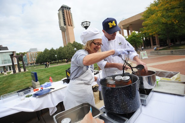 Residential Dinning Services employees Melissa and Buzz Cummings work together while canning salsa during a demo during the MFarmers' Market set up outside of the Duderstadt Center on Thursday. Melanie Maxwell I AnnArbor.com
